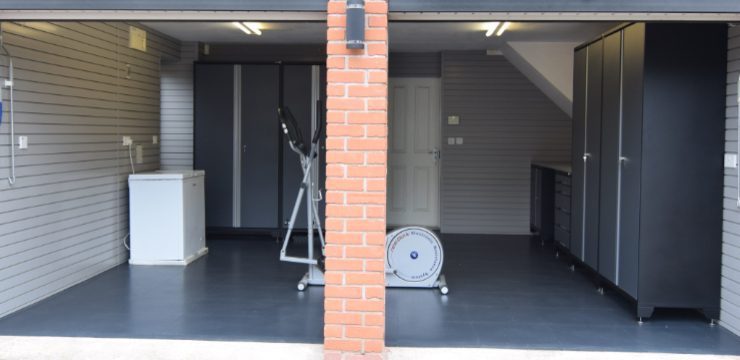 A tidy garage after makeover by GaragePride with gym equipment inside